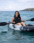Woman paddling Cambridge Kayaks Neptune single sit on top kayak on calm sea near coastline