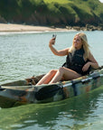 Woman taking selfie on Cambridge Kayaks Neptune single sit on top kayak in calm coastal water