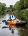 Man kayaking in Cambridge Kayaks Neptune single sit on top kayak on river near stone bridge