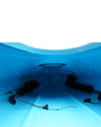 Cockpit view of the Cambridge Kayaks touring kayak in light blue, showing padded seat, hatch opening, and deck lines.