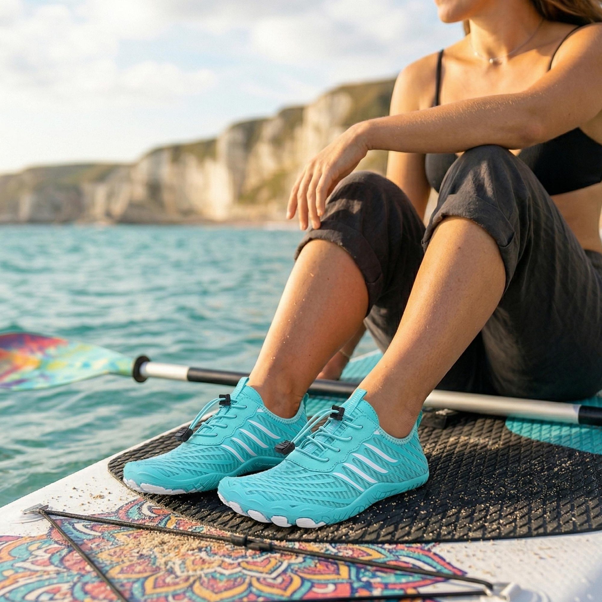 Womens and mens aqua shoes worn on paddleboard showing quick dry, non slip design for water sports and kayaking
