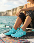 Womens and mens aqua shoes worn on paddleboard showing quick dry, non slip design for water sports and kayaking