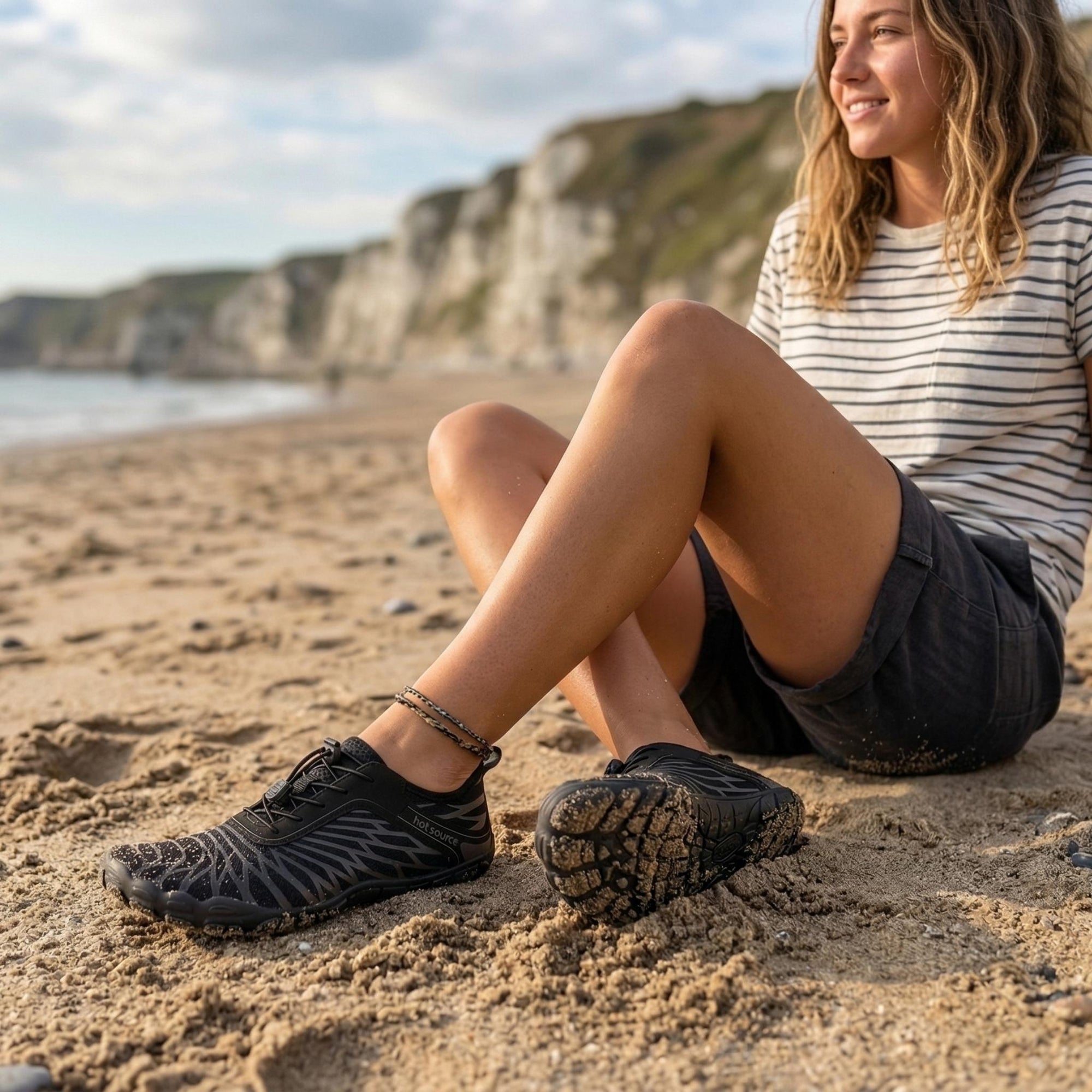 Woman relaxing on beach wearing lightweight water shoes designed for comfort, breathability and summer use
