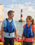 Couple wearing blue Cambridge Kayaks buoyancy aids beside kayaks