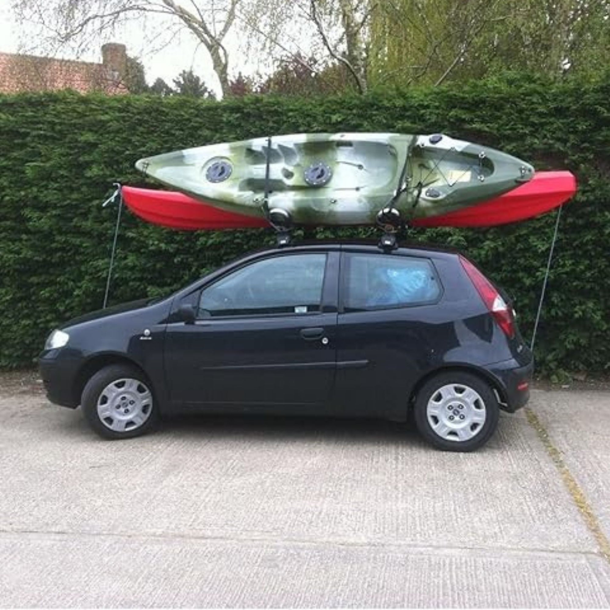 Cambridge Kayaks 1st Edition Folding J Bars carrying kayak securely on car roof, demonstrating real-world use.