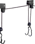 Close-up of the Cambridge Kayaks ceiling hoist showing the wall-mounted pulley system and attached lifting hooks.