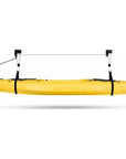 Cambridge Kayaks ceiling hoist system suspending a yellow kayak horizontally with adjustable straps and pulleys.