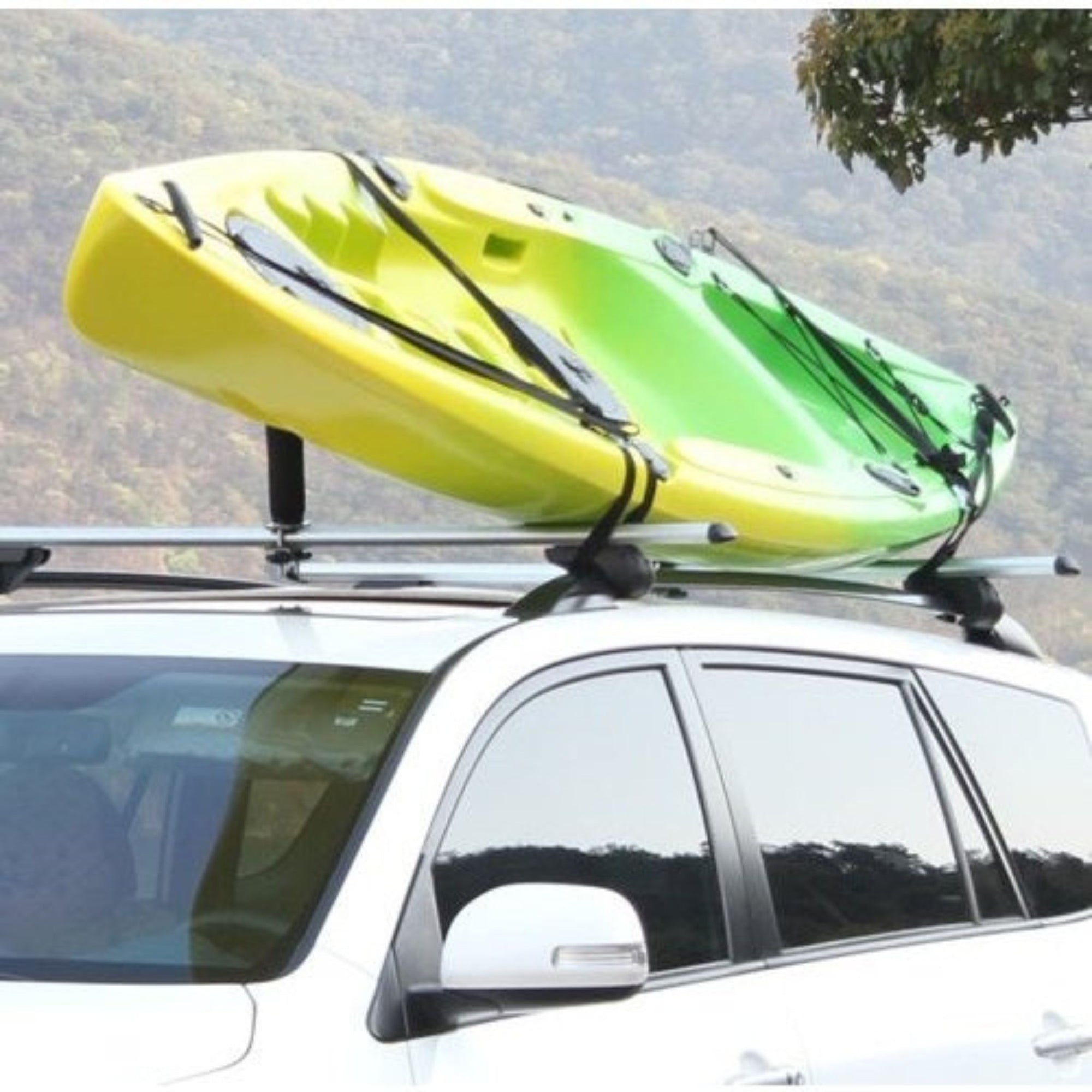 Roof-mounted Cambridge Kayaks Centre Post system carrying a yellow kayak, illustrating balance, spacing, and strong tie-down support during travel.
