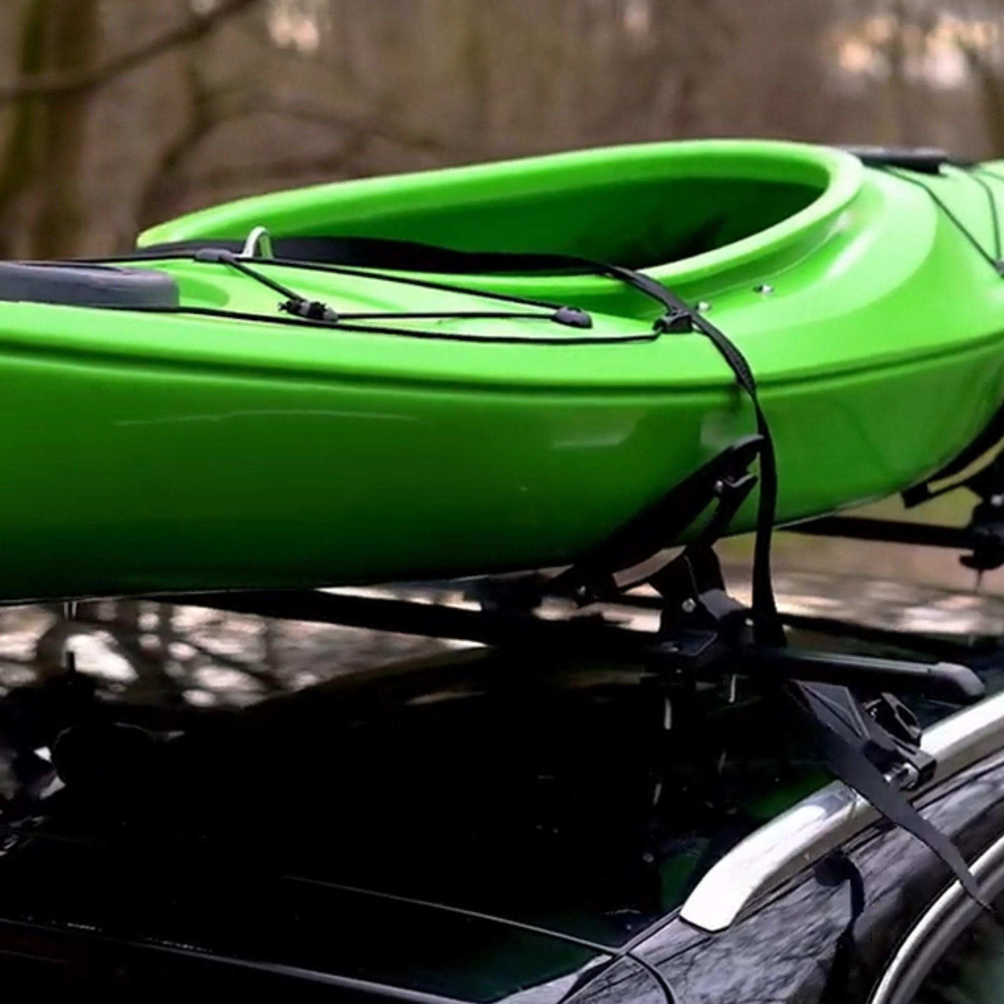 Close-up of the Cambridge Kayaks Cradle Support system showing the kayak resting securely in the padded brackets with tight roof rack straps.