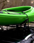 Close-up of the Cambridge Kayaks Cradle Support system showing the kayak resting securely in the padded brackets with tight roof rack straps.