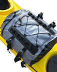 The Cambridge Kayaks Deluxe 15L Dry Deck Bag securely mounted on a yellow kayak, showing how it attaches using adjustable clips and straps for on-deck waterproof storage.