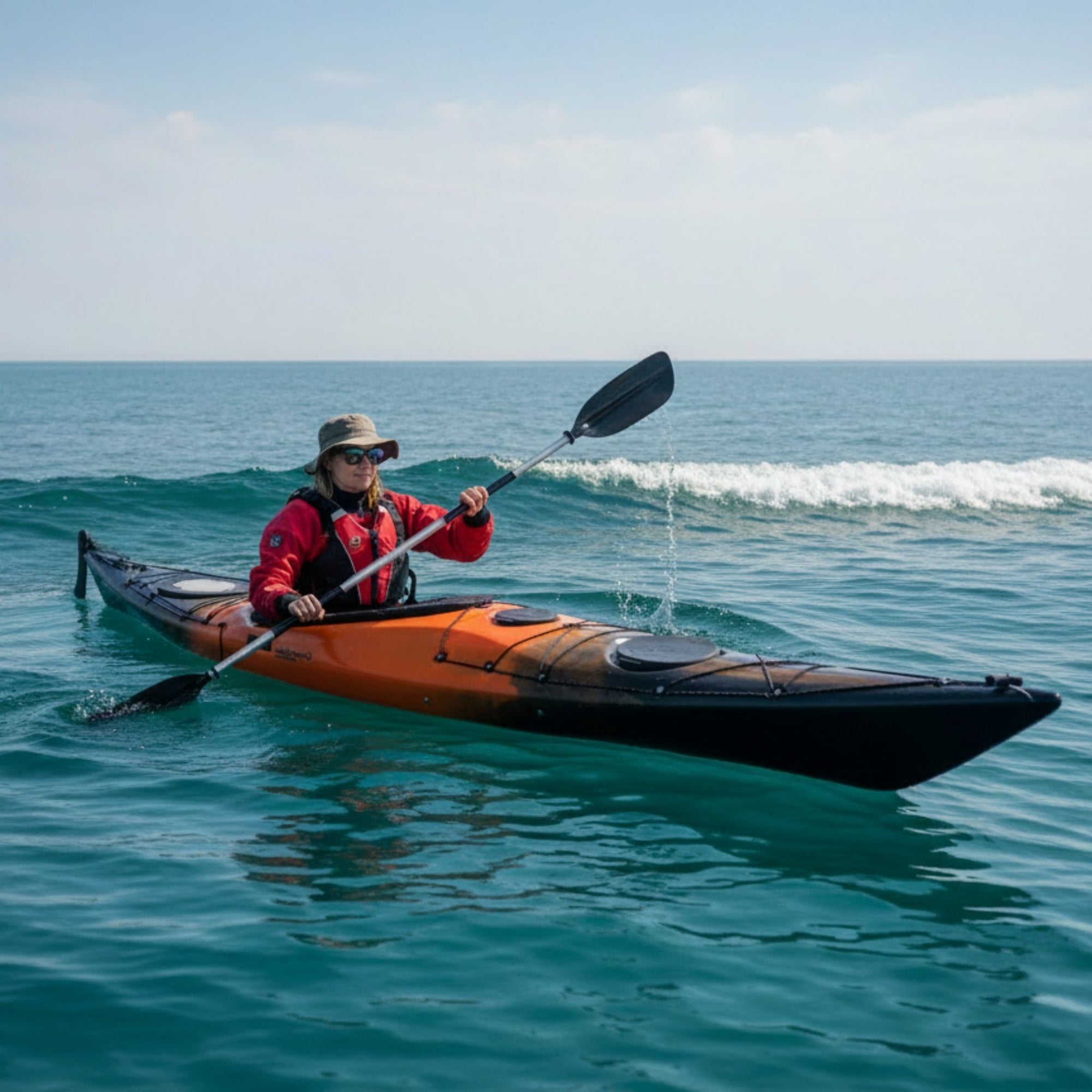 Person paddling Cambridge Kayaks Explorer 430 sit inside touring kayak in small coastal waves