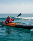 Person paddling Cambridge Kayaks Explorer 430 sit inside touring kayak in small coastal waves