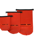 Three red Cambridge Kayaks dry bags displayed together in different sizes to illustrate capacity options. Each bag includes a roll-top closure, buckle clip, and waterproof welded seams — ideal for multi-day kayaking trips or beach outings.