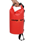 Single red Cambridge Kayaks waterproof dry bag standing upright with shoulder strap attached, designed for portability and outdoor waterproof storage.