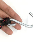 Detail view of a person holding the Cambridge Kayaks tie down hook, highlighting the strong grip and secure attachment point for vehicle or kayak fitting.