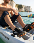 Man wearing water shoes while kayaking showing quick dry material and non slip grip for paddling and water sports
