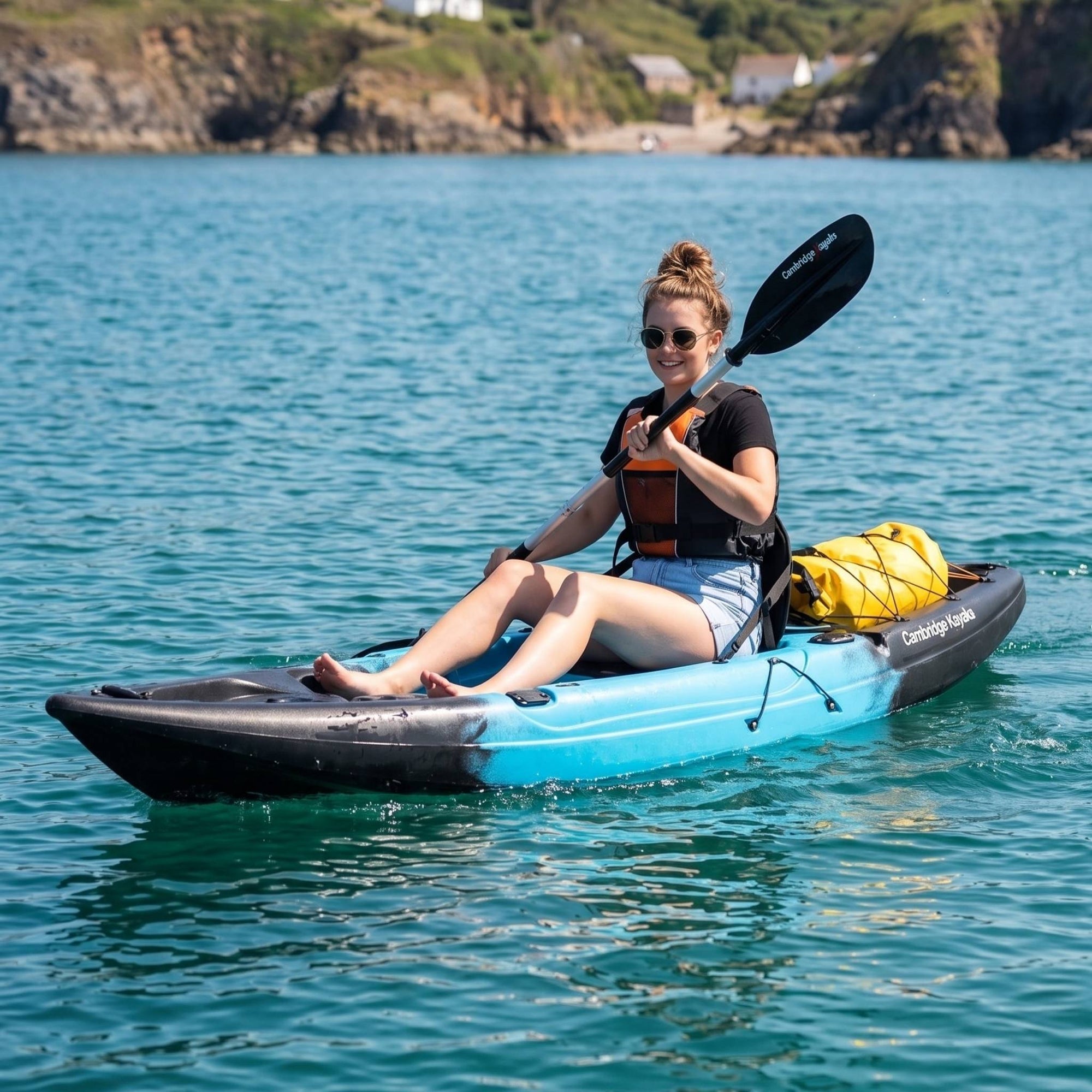 Woman using single sit on top kayak for leisure and fishing on coastal water