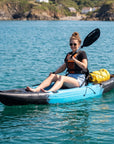 Woman using single sit on top kayak for leisure and fishing on coastal water