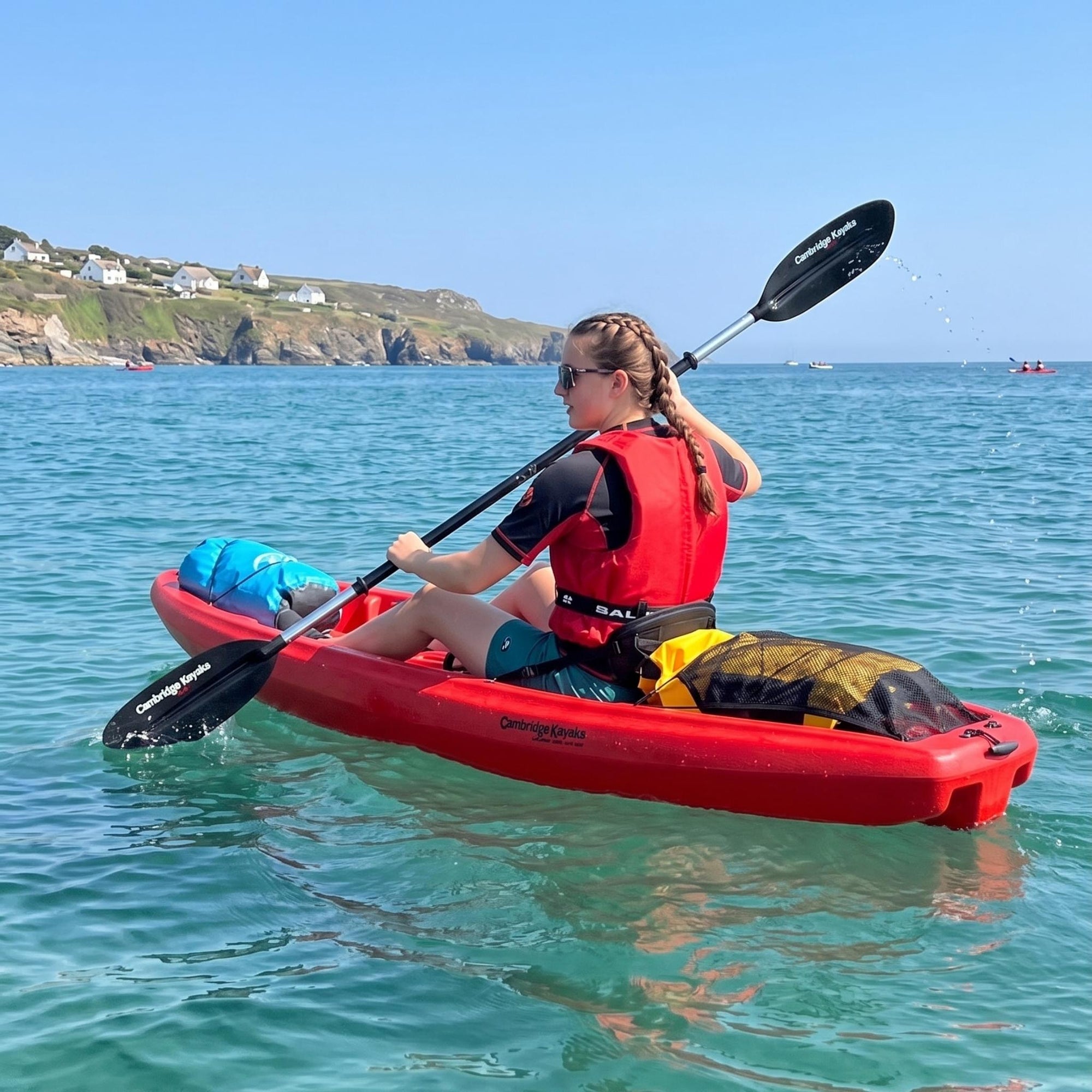 Side view of person kayaking in single sit on top kayak on clear sea