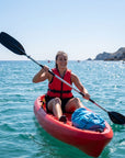 Person paddling single sit on top kayak on the sea wearing life jacket