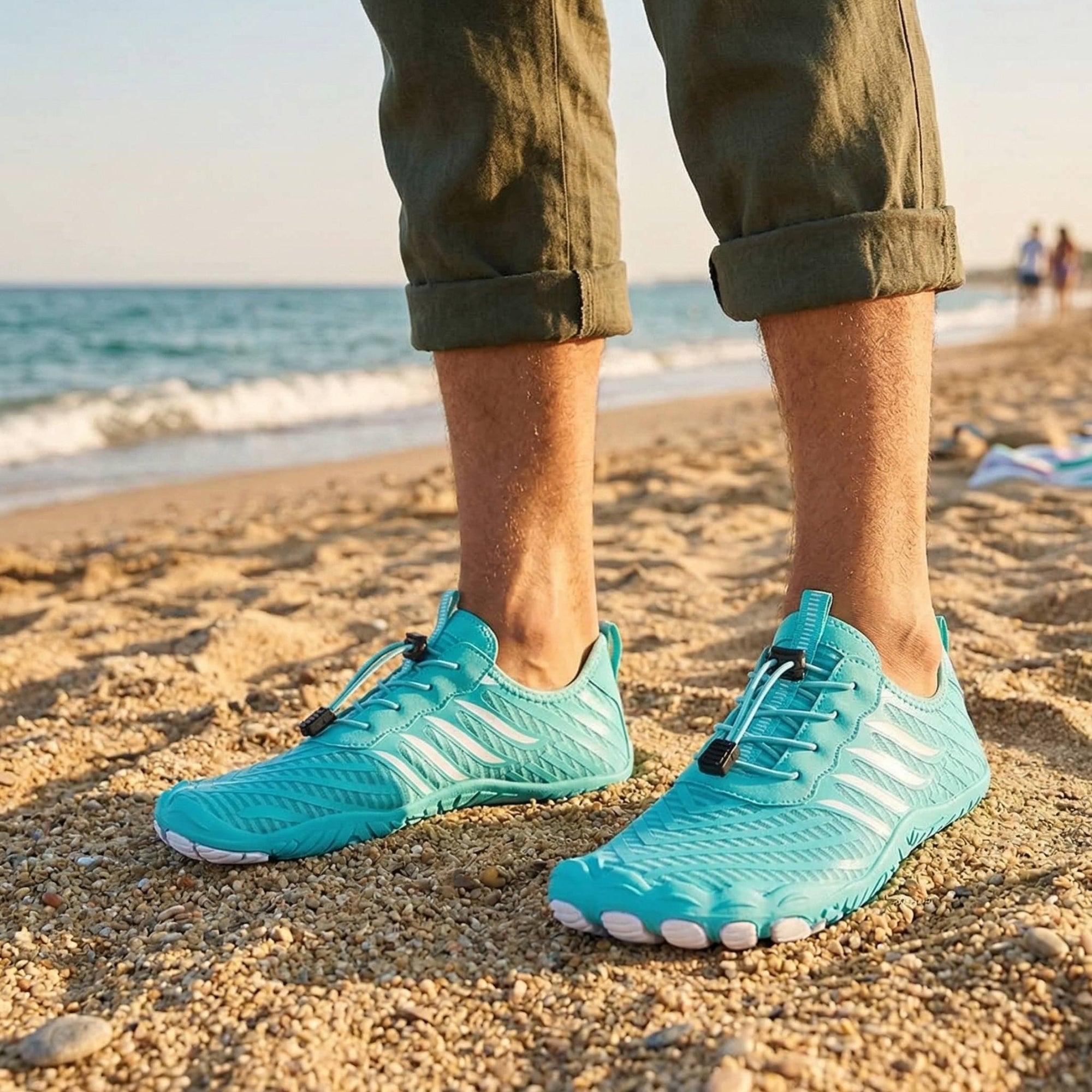 Turquoise water shoes worn on beach showing lightweight design and non slip grip for walking on sand and pebbles