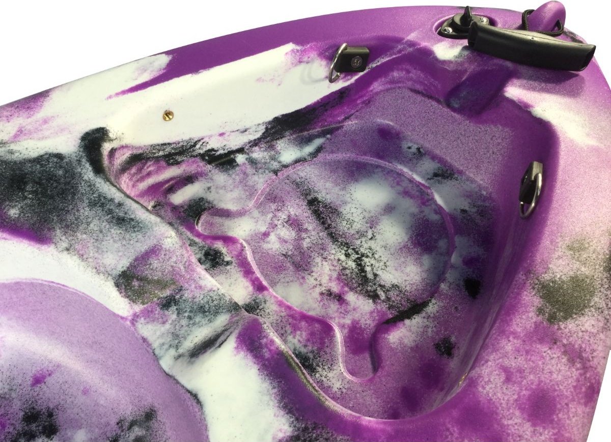 Close-up view of Cambridge Kayaks Guppy purple and white kayak cockpit showing molded seat and footwell details for comfort and stability.